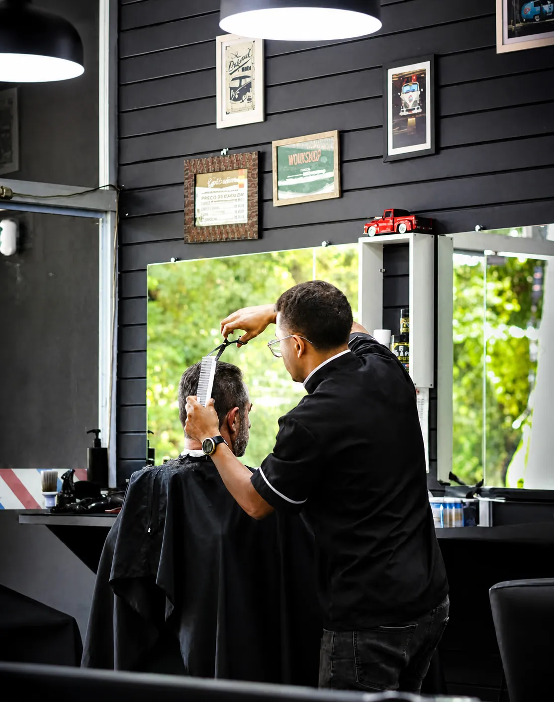 Barbeiro finalizando corte com tesoura no salão